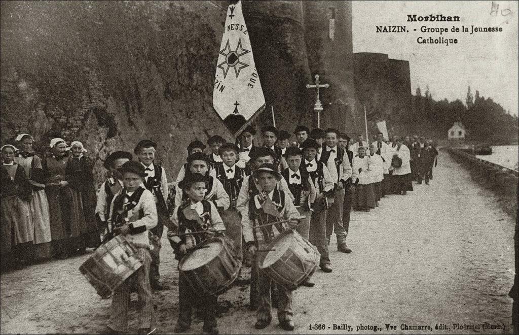 Défilé d'un groupe de la Jeunesse Catholique sur la commune de Naizin au début des années 1900.